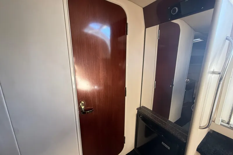 Slide: The Image of Interior of 2004 Formula 370 Super Sport boat, featuring wooden door and compact kitchenette. - 44