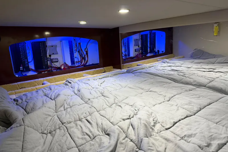 Slide: The Image of Interior of 2004 Formula 370 Super Sport boat with blue-lit control panels and cozy bedding. - 48