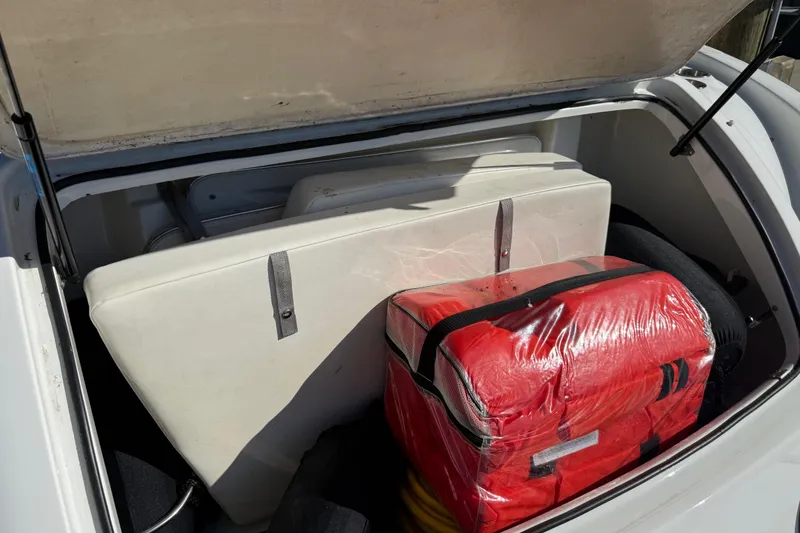 Slide: The Image of Open storage compartment of a 2004 Formula 370 Super Sport boat with red bag and cushions. - 52