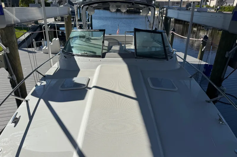 Slide: The Image of 2004 Formula 370 Super Sport boat docked, showcasing sleek deck and windshield design. - 53