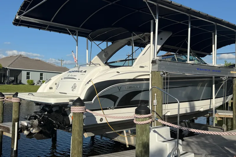 Slide: The Image of 2004 Formula 370 Super Sport boat docked under a canopy. - 8