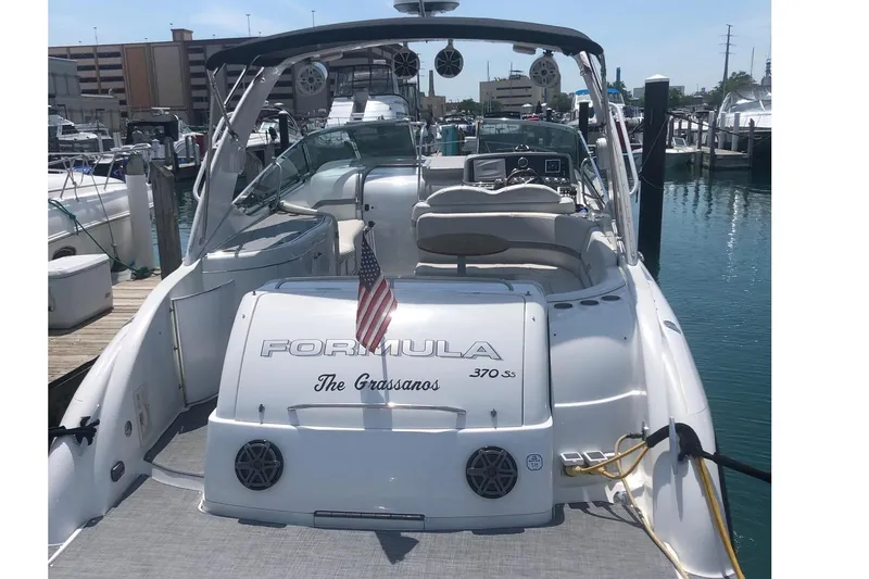 Slide: The Image of 2004 Formula 370 Super Sport boat docked at marina, rear view with American flag. - 9
