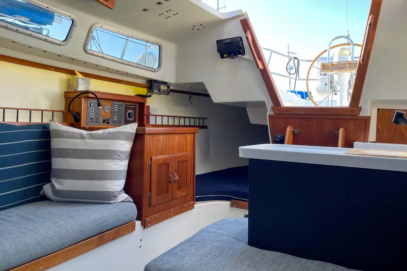 Slide: The Image of Interior of a 1981 Catalina 30 sailboat with cozy seating and navigation equipment. - 16