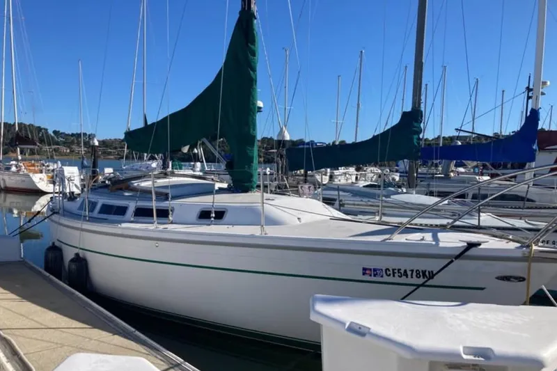 Slide: The Image of 1981 Catalina 30 sailboat docked in a marina under clear blue skies. - 2