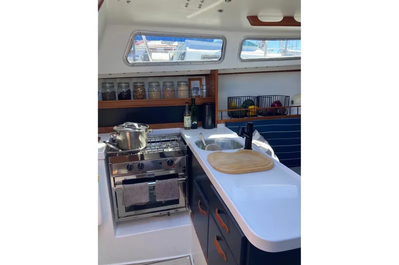 Slide: The Image of 1981 Catalina 30 yacht kitchen with stove, sink, and storage jars. - 7