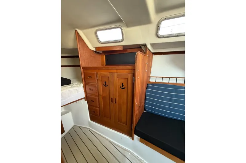 Slide: The Image of Interior of 1981 Catalina 30 sailboat with wooden cabinetry and striped seating. - 8