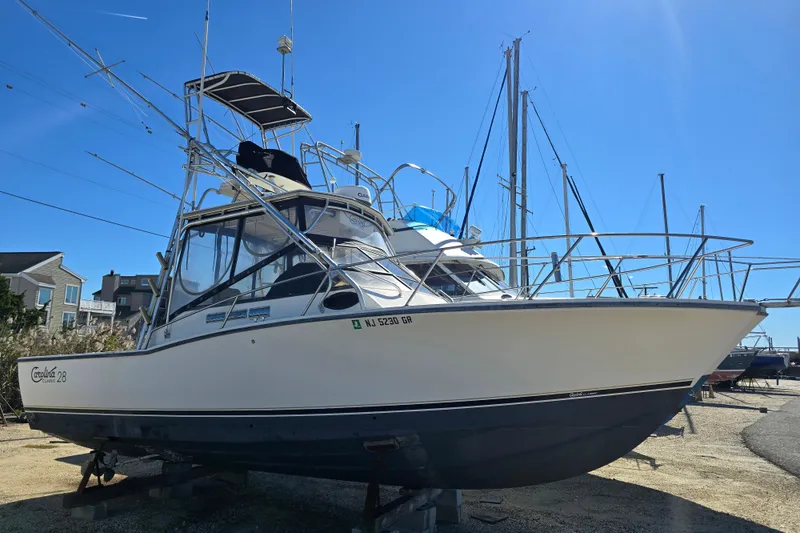 The Image of 2002 Carolina Classic 28 Express boat on dry dock under clear blue sky. - 1