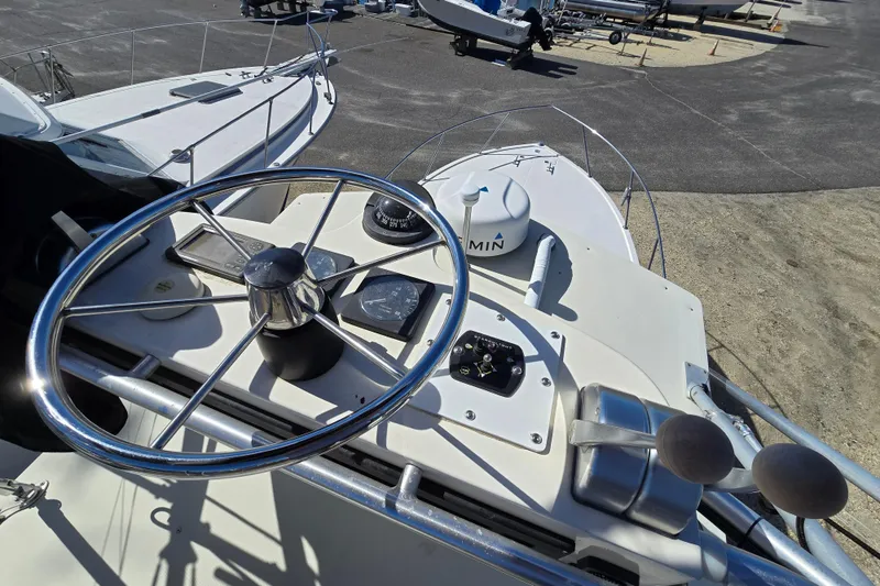 Slide: The Image of 2002 Carolina Classic 28 Express boat helm with steering wheel and navigation instruments. - 15