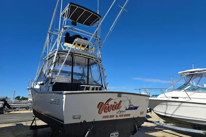 Slide: The Image of 2002 Carolina Classic 28 Express boat on trailer under clear blue sky. - 3