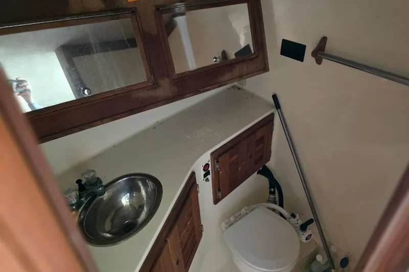 Slide: The Image of 2002 Carolina Classic 28 Express boat bathroom with sink, mirror, and toilet. - 7