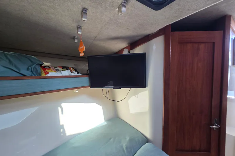 Slide: The Image of Interior of 2002 Carolina Classic 28 Express with TV, bunk, and wooden door. - 9