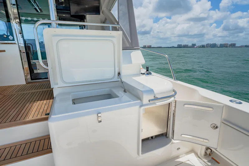 Slide: The Image of 2024 Riviera 505 SUV yacht deck with open storage compartments and ocean view. - 18