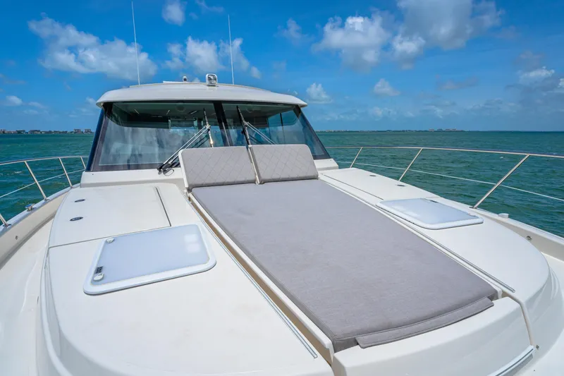 Slide: The Image of 2024 Riviera 505 SUV yacht with sunbed on deck, cruising on a sunny day. - 24