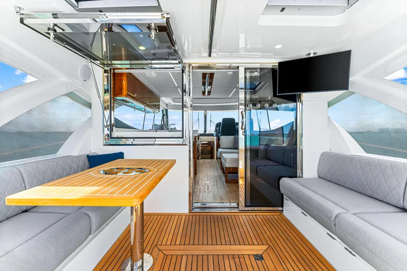 Slide: The Image of 2024 Riviera 505 SUV interior with modern seating, wooden table, and mounted TV. - 26