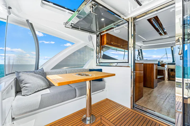 Slide: The Image of 2024 Riviera 505 SUV interior with ocean view, modern seating, and wooden table. - 27