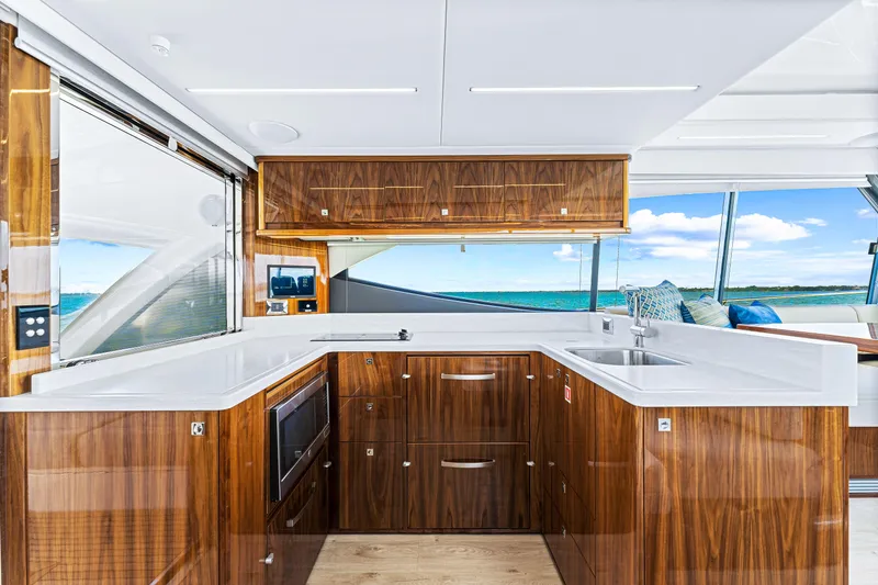 Slide: The Image of 2024 Riviera 505 SUV yacht kitchen with modern wood cabinetry and ocean view. - 35