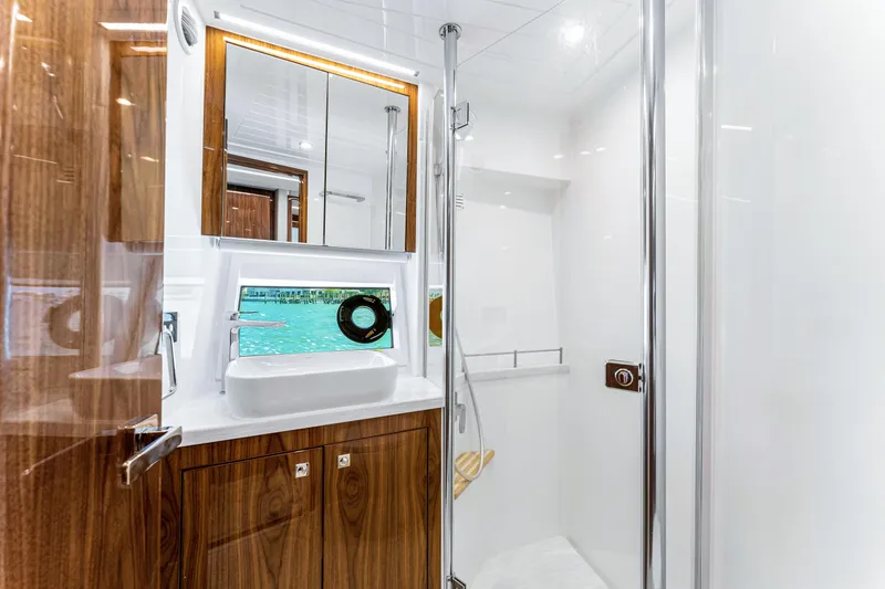Slide: The Image of Luxurious bathroom in 2024 Riviera 505 SUV yacht with wooden cabinetry and modern fixtures. - 48