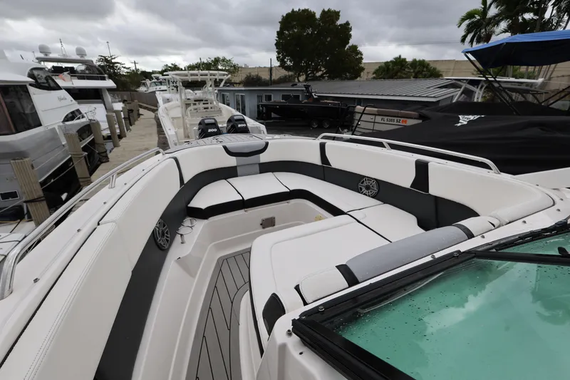 Slide: The Image of 2022 Chaparral 280 OSX boat with spacious seating at a marina. - 15