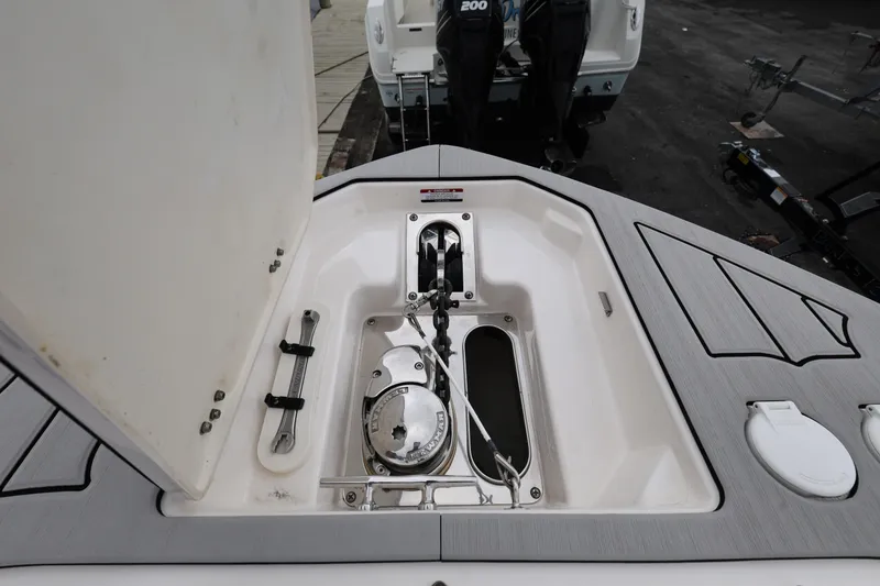 Slide: The Image of 2022 Chaparral 280 OSX boat anchor compartment with open hatch and tools. - 16
