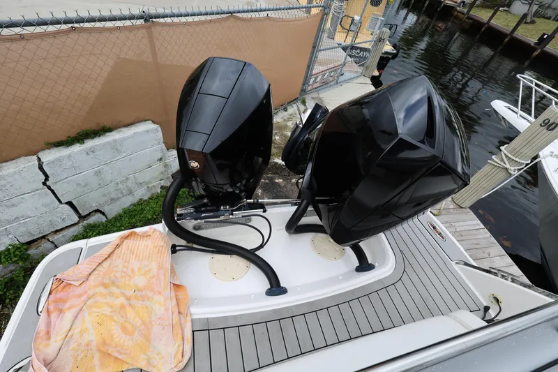 Slide: The Image of 2022 Chaparral 280 OSX boat with dual outboard engines docked by a canal. - 24