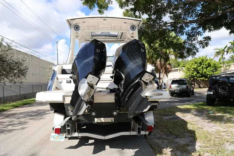 Slide: The Image of 2022 Chaparral 280 OSX boat with dual outboard engines parked on a sunny street. - 4