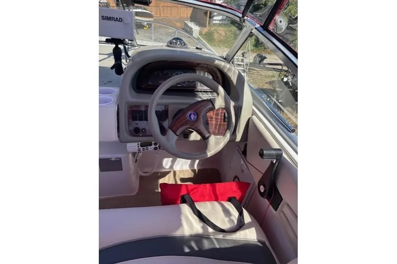 Slide: The Image of 2000 Four Winns 238 Vista boat cockpit with steering wheel and navigation equipment. - 20
