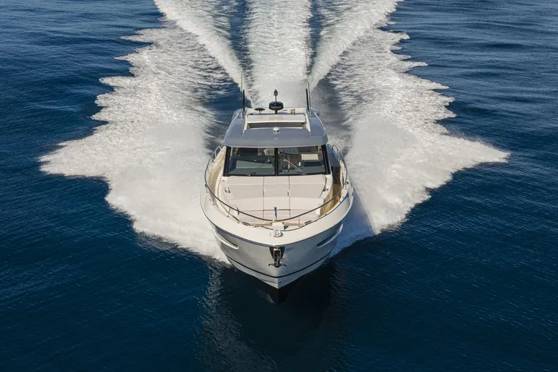 The Image of 2026 Riviera 4300 Sport Express yacht cruising on open water, creating a dynamic wake. - 0