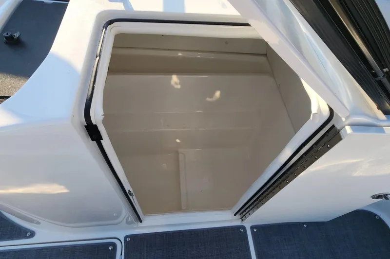 Slide: The Image of 2022 Bayliner VR6 Bowrider OB storage compartment, open and empty, with white interior. - 11