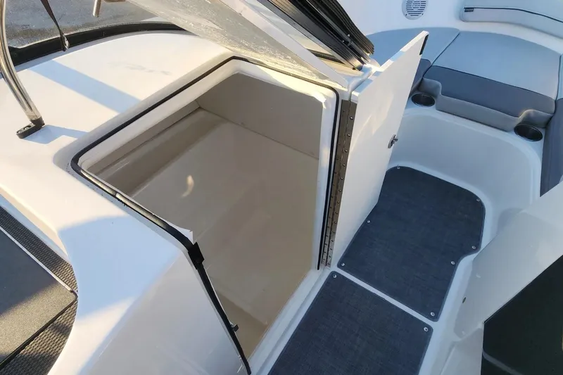Slide: The Image of 2022 Bayliner VR6 Bowrider OB interior with open storage compartment and seating area. - 12