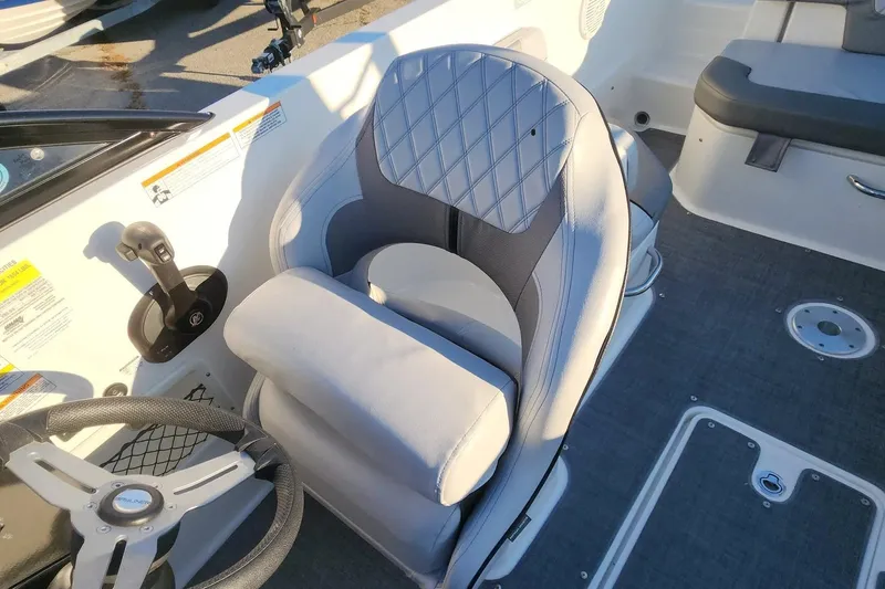 Slide: The Image of 2022 Bayliner VR6 Bowrider OB interior with steering wheel and cushioned seat. - 17