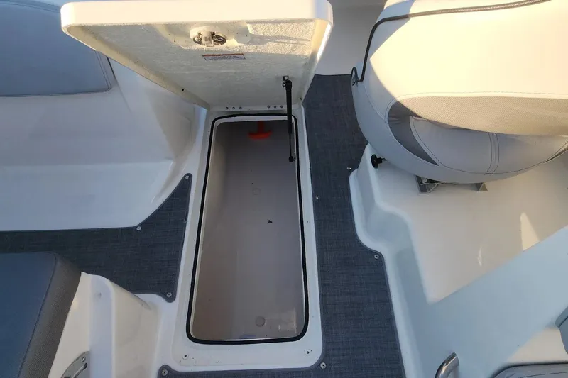 Slide: The Image of 2022 Bayliner VR6 Bowrider OB storage compartment with open hatch and seating area. - 3