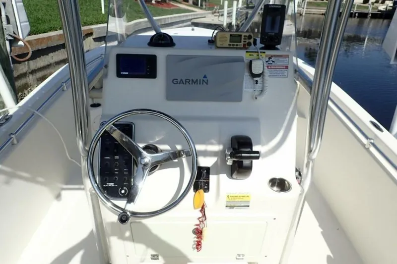 Slide: The Image of 2023 Cobia 217 CC boat console with Garmin navigation and steering wheel. - 11