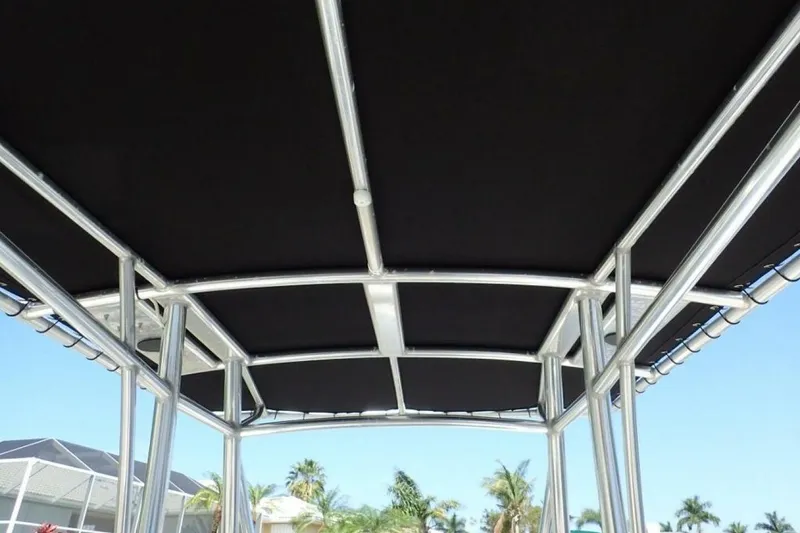 Slide: The Image of T-top canopy of 2023 Cobia 217 CC boat with metal frame against blue sky. - 16