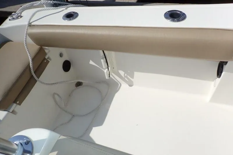 Slide: The Image of 2023 Cobia 217 CC boat interior with beige seating and rope detail. - 20