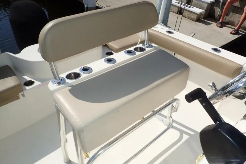 Slide: The Image of 2023 Cobia 217 CC boat interior with beige seating and rod holders. - 22