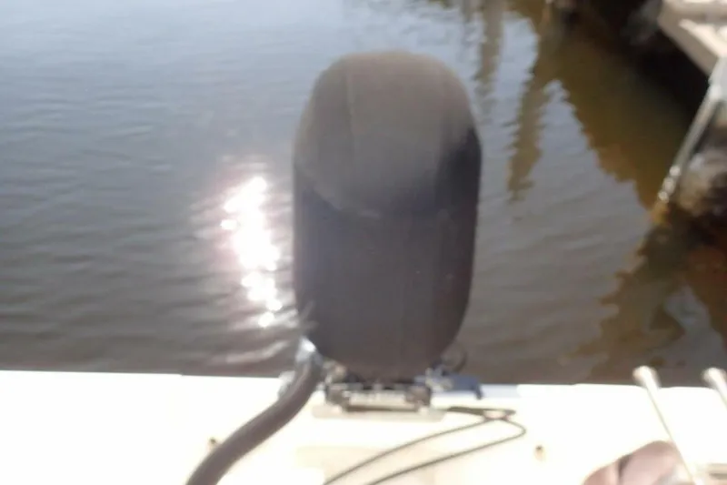 Slide: The Image of Outboard motor on a 2023 Cobia 217 CC boat by the water. - 23