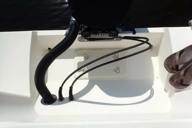Slide: The Image of 2023 Cobia 217 CC boat deck with hydraulic steering and sandals. - 24