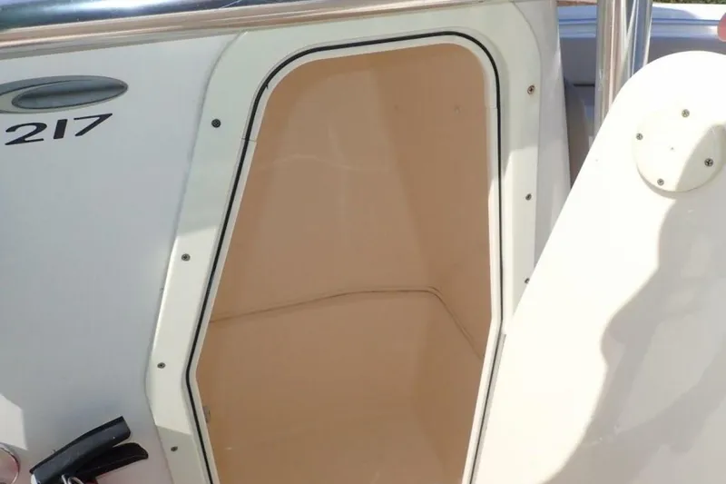 Slide: The Image of 2023 Cobia 217 CC boat storage compartment with open hatch. - 25