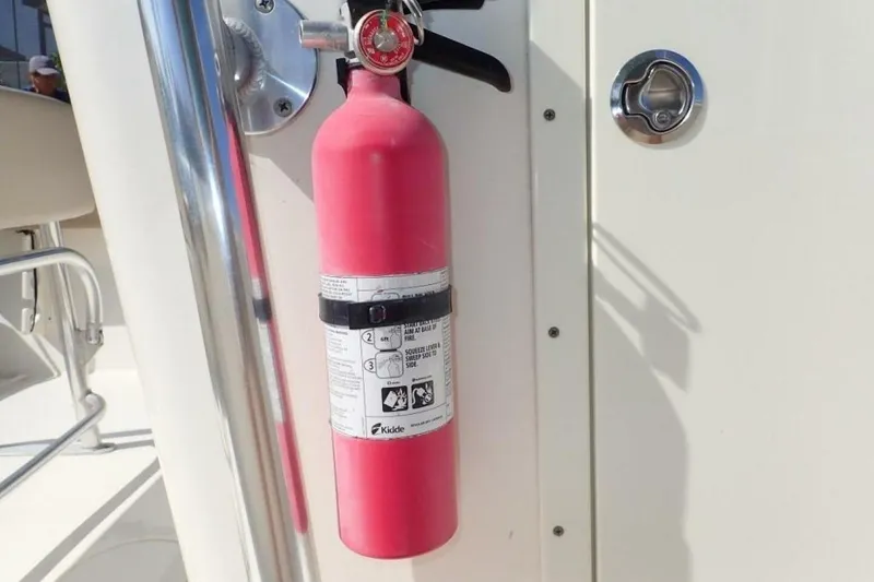 Slide: The Image of Red fire extinguisher mounted on 2023 Cobia 217 CC boat. - 28