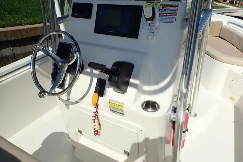 Slide: The Image of 2023 Cobia 217 CC boat console with steering wheel and navigation controls. - 31