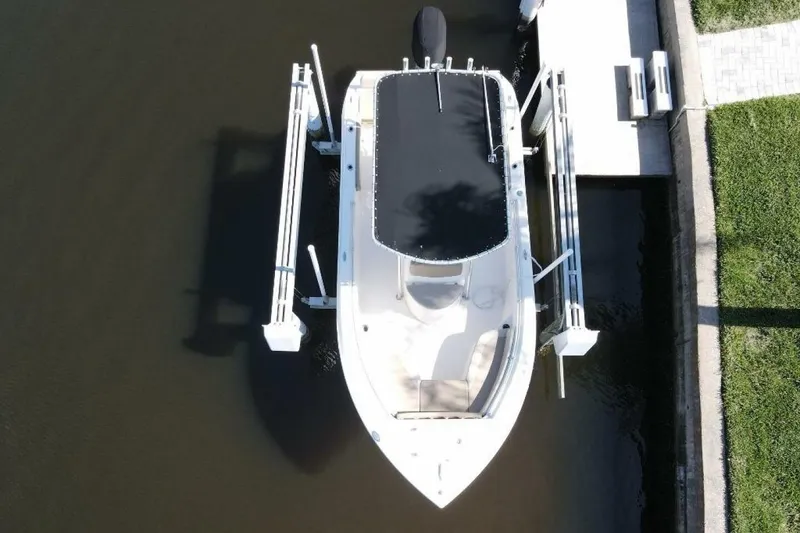 Slide: The Image of 2023 Cobia 217 CC boat docked, aerial view, covered, in a marina setting. - 6