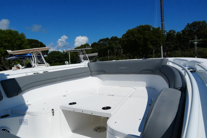 Slide: The Image of 2025 NauticStar 292 Legacy boat with spacious seating under clear blue sky. - 13