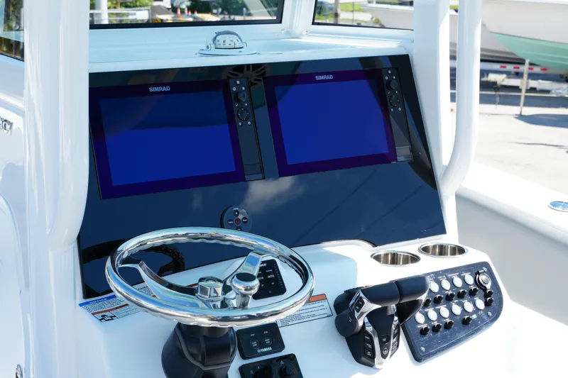 Slide: The Image of 2025 NauticStar 292 Legacy boat dashboard with dual Simrad displays and steering wheel. - 25