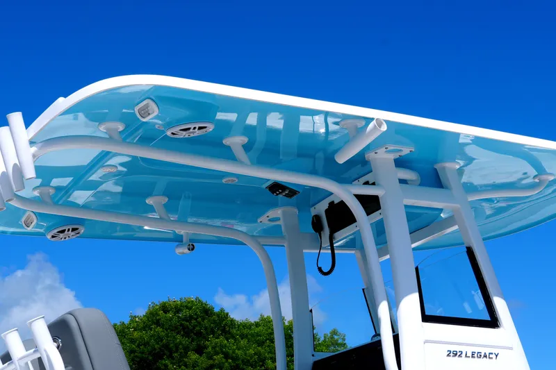Slide: The Image of 2025 NauticStar 292 Legacy boat with blue T-top against clear sky. - 8