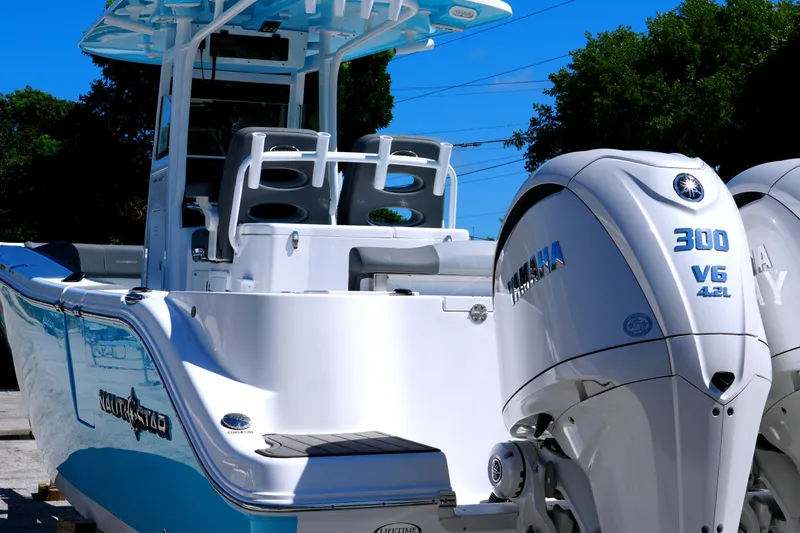 Slide: The Image of 2025 NauticStar 292 Legacy boat with Yamaha 300 V6 engines, docked outdoors. - 9