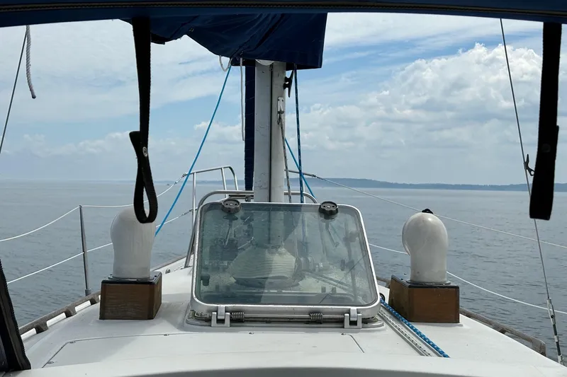 Slide: The Image of 1982 C&C Landfall 35 sailboat deck view with ocean and cloudy sky. - 2