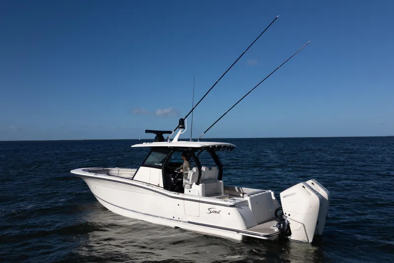 Slide: The Image of 2024 Scout 330 LXF boat on open water, featuring dual Mercury engines. - 10