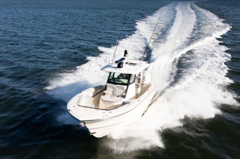 Slide: The Image of 2024 Scout 330 LXF boat cruising swiftly on open water. - 14