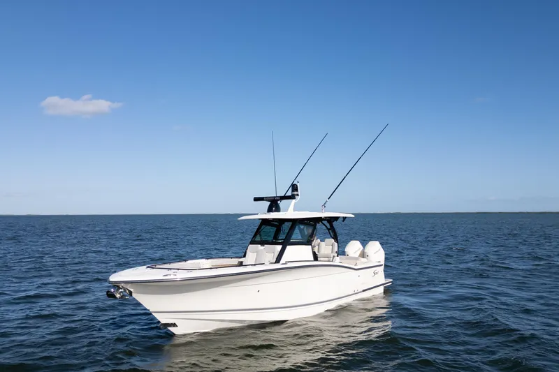 Slide: The Image of 2024 Scout 330 LXF boat on open water under clear blue sky. - 16