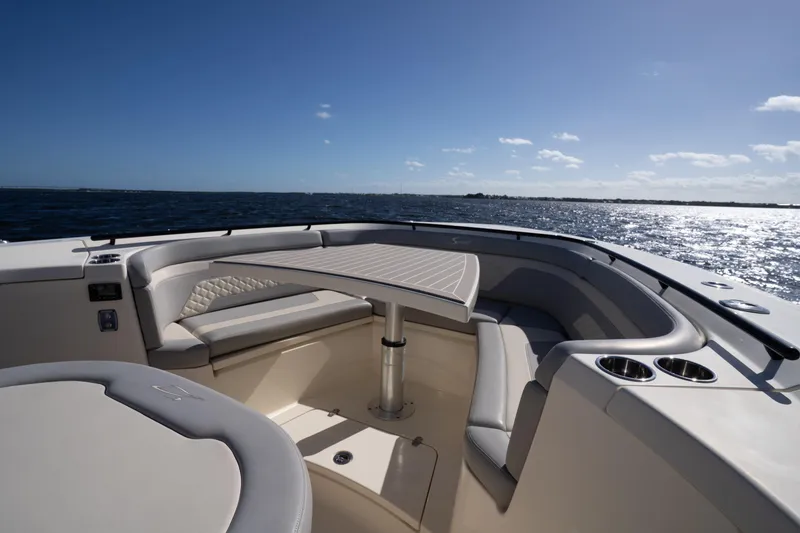 Slide: The Image of 2024 Scout 330 LXF boat interior with seating and table, overlooking the ocean. - 25